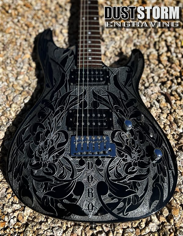 Custom laser engraved glossy black Ibanez guitar with silver floral engraving. Lettering Doro at bottom under pickups