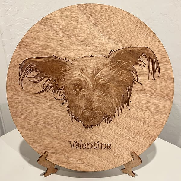 Cute hairy dog portrait laser engraved on mahagony wood circle with Valentine written underneath.